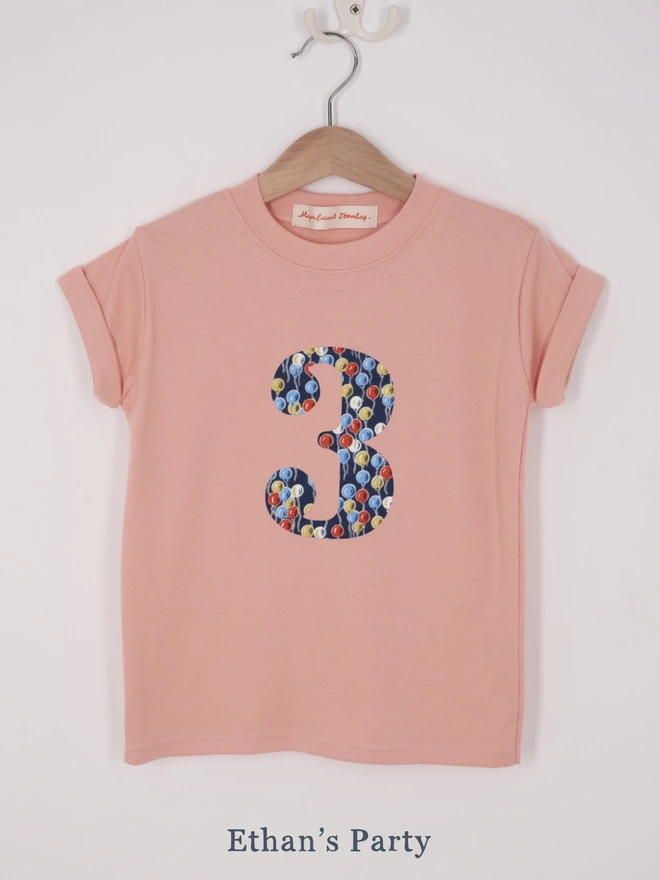 a pink t-shirt appliquéd with a number 3 in a balloon Liberty print