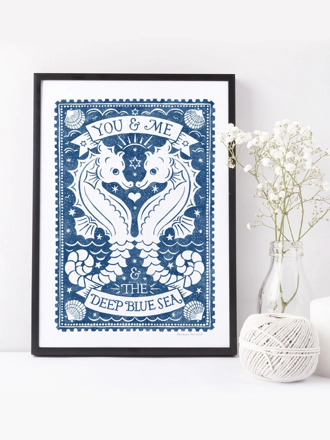 blue and white watercolour seahorse print in black frame with white flowers