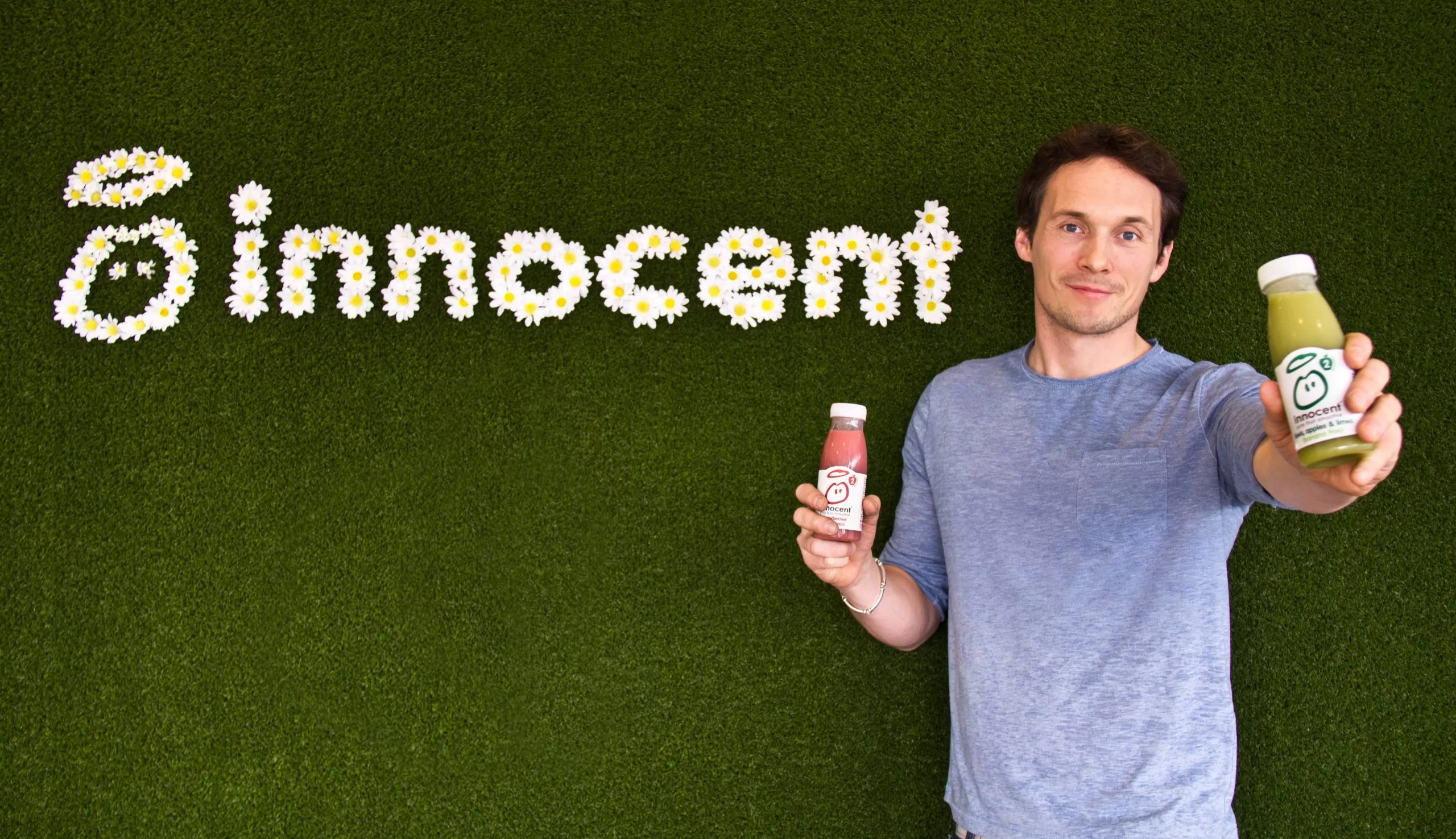 Richard Reed CBE, co-founder of Innocent and JamJar Investments, smiling at the camera holding Innocent smoothies. 