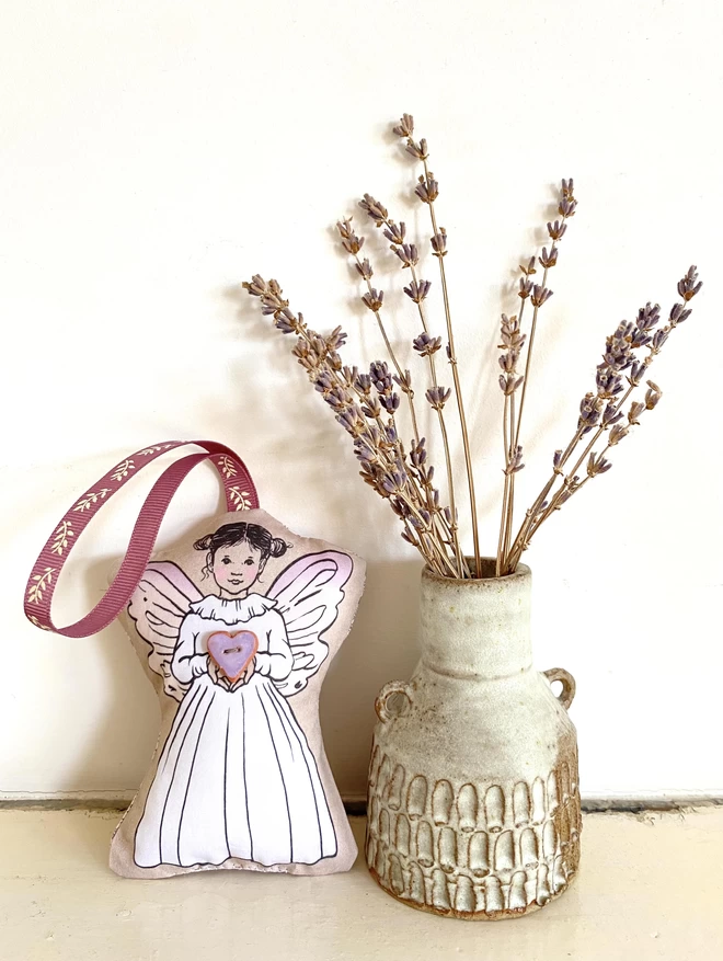 lilac fairy plush stood next to vase with dried lavender