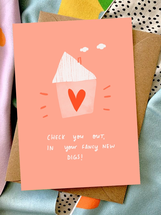 Card is laid on colourful blankets. Card reads 'Check you out, in your fancy new digs!'