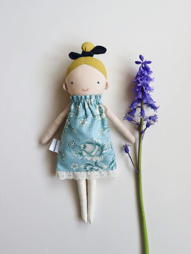 Cotton and linen doll with fair skin and blonde hair, wearing vintage inspired flower print in blue.