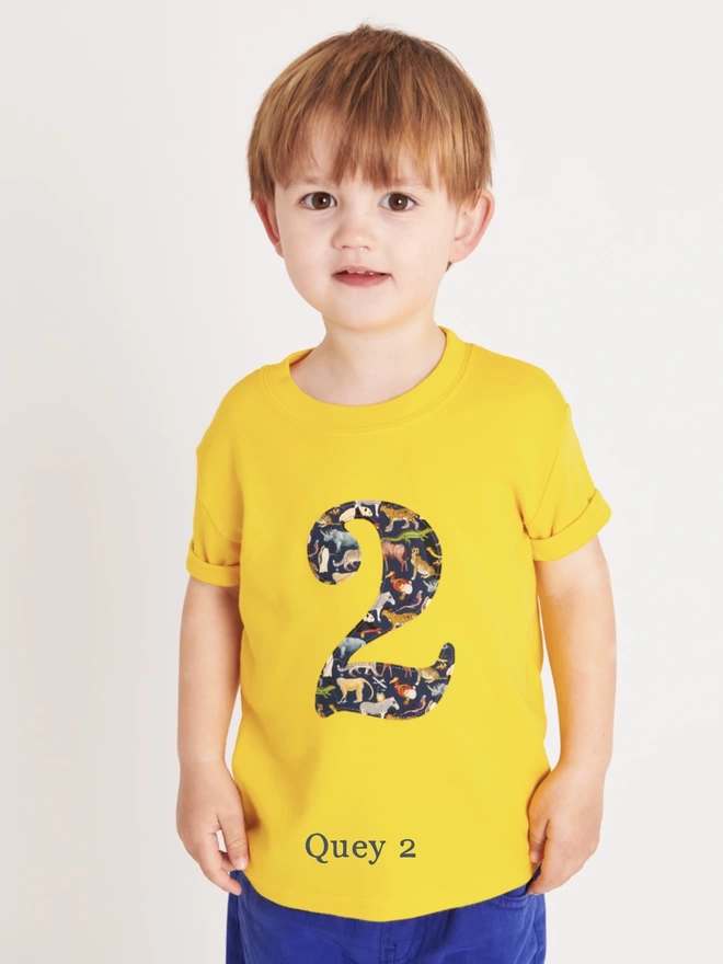 a yellow t-shirt with an initial in a zoo animal print on front
