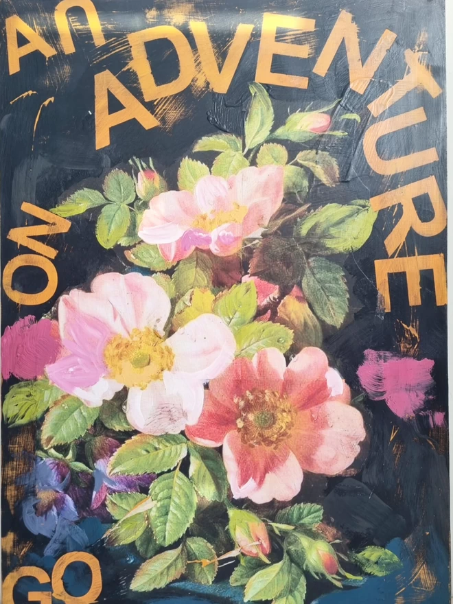 Large painted wall panel in black with large decoupage wild roses and orange text reading ‘go on an adventure’.