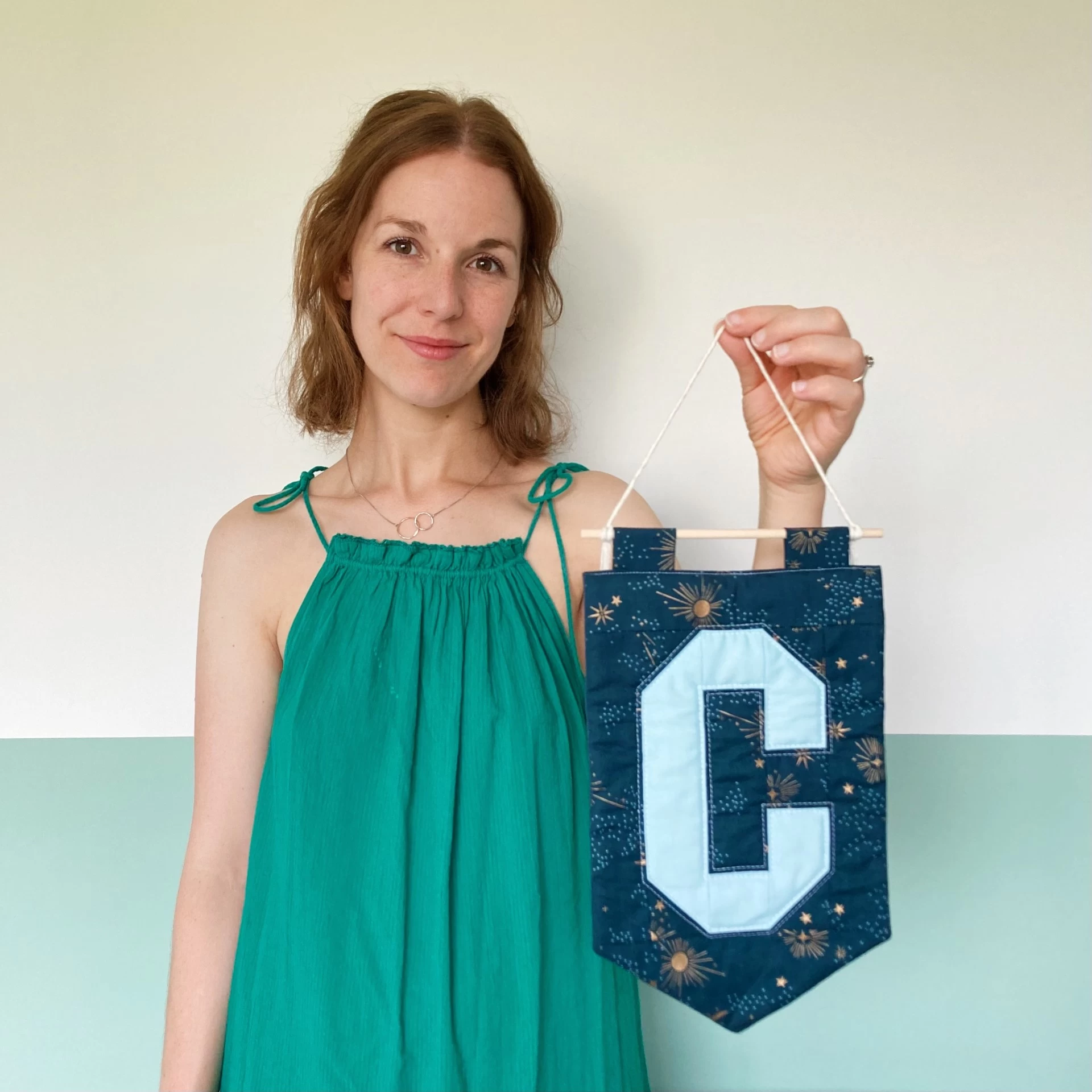 Woman holding a quilted letter wall hanging