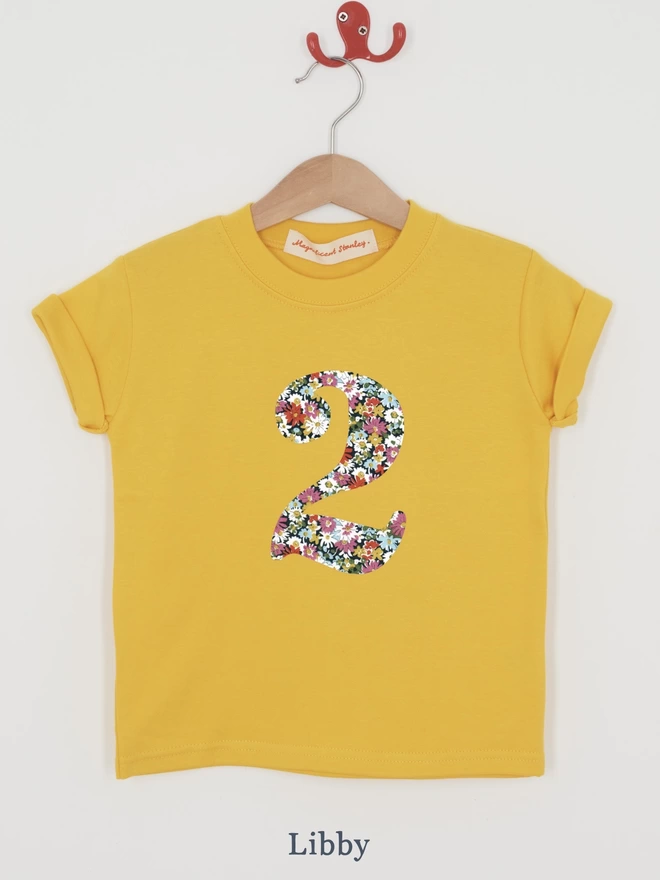 a yellow t-shirt with a floral print number 2 on front