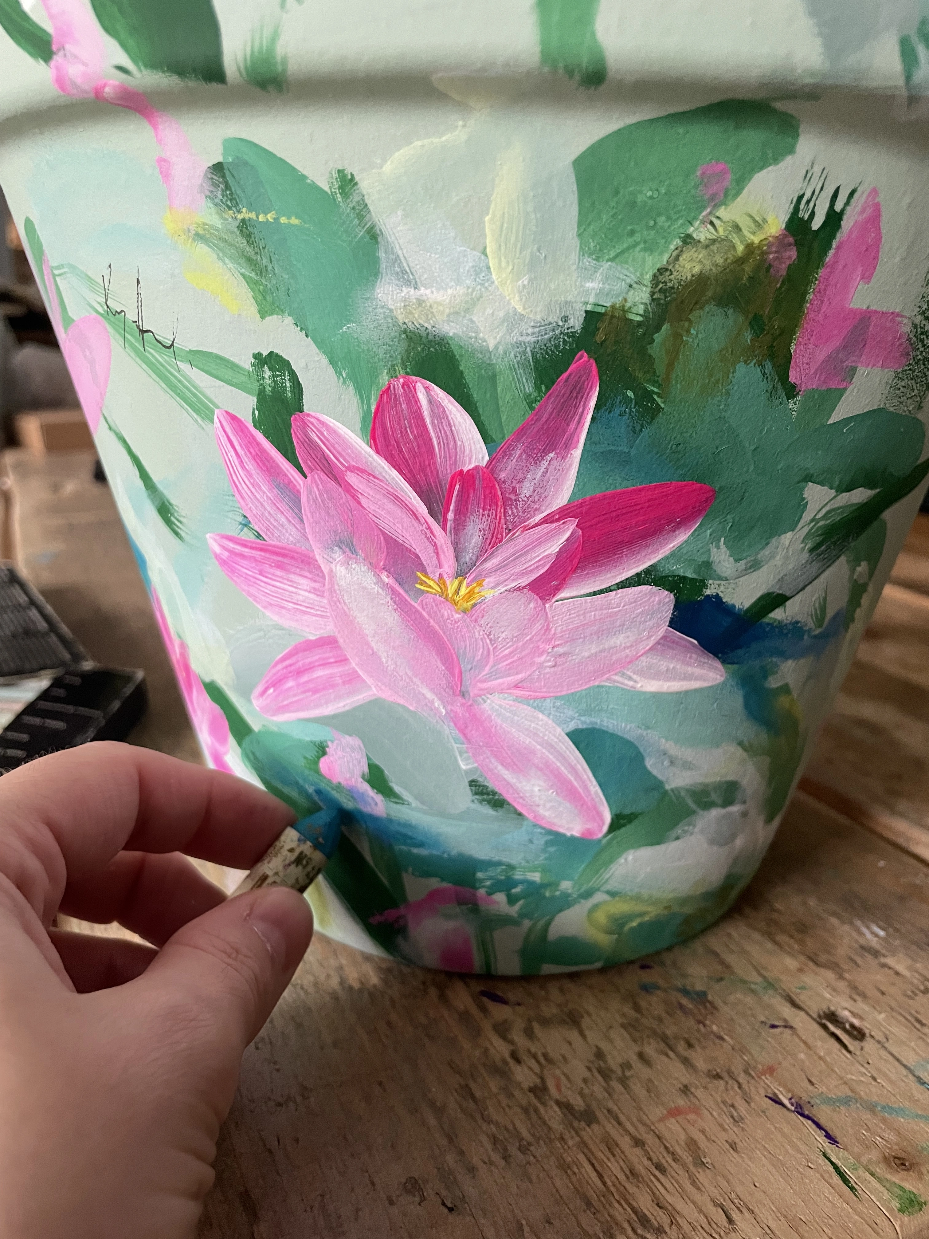 Kate, the artist is hand painting a plant pot in her studio for EmlynDelaney&Co
