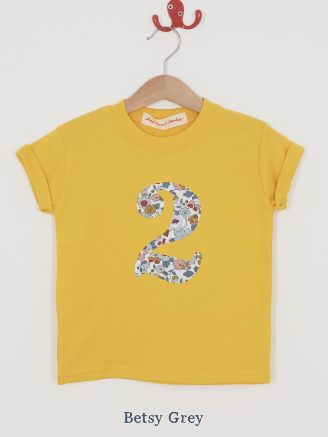 a yellow t-shirt with a Liberty floral print number 2 on front