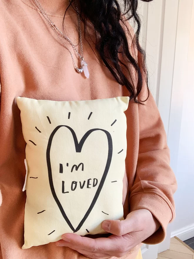 A mini plushie pillow that says 'I'm Loved'