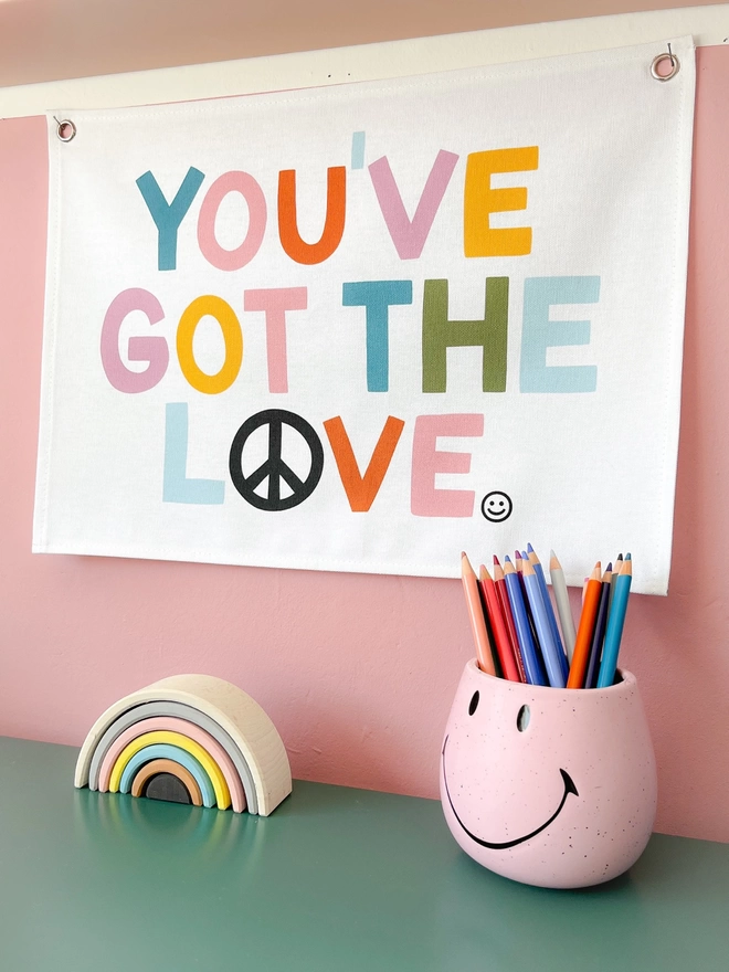 You’ve got the love wall hanging on a pink background wall
