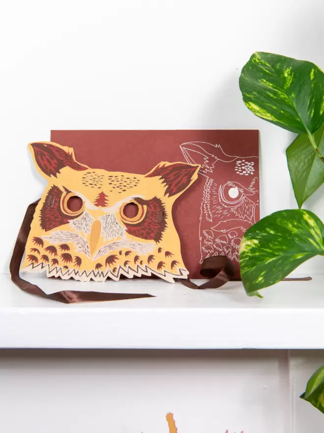 Full shot of image of brown owl head and matching brown envelope with an owl motif