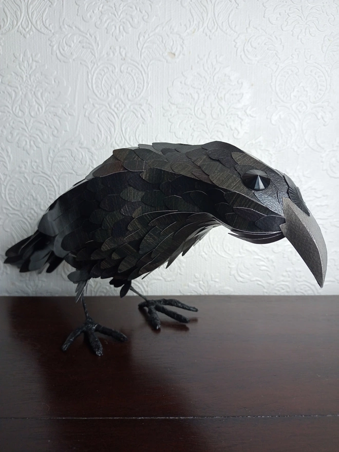 standing sculpture of a black crow bird