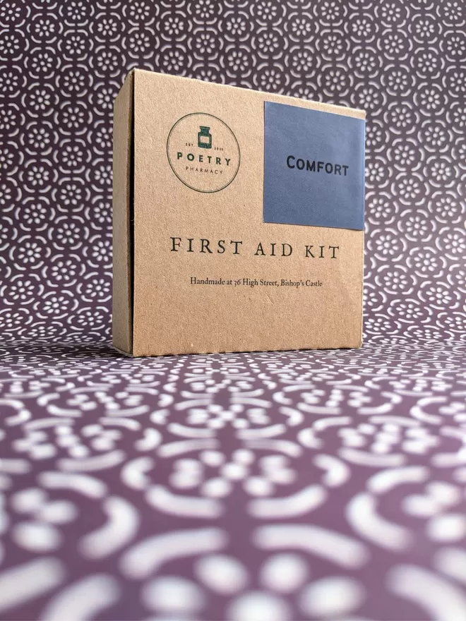 Cardboard Comfort First Aid Kit, closed on patterned paper