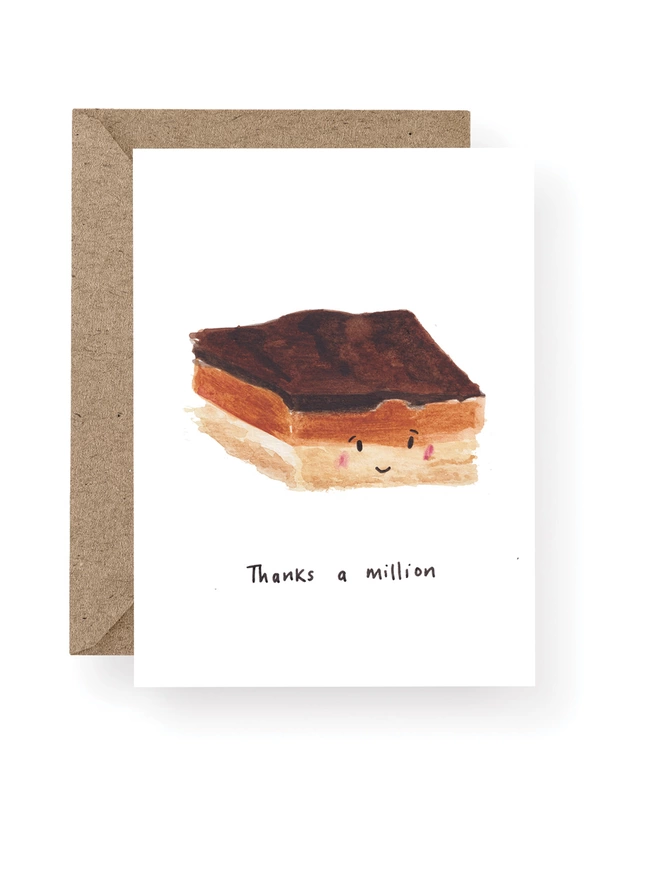 Thanks a Million Thank You Card.  Card Has a White Base With Hand Painted Millionaire’s Shortbread adorned with a Smiley Face.  Sitting On A Recycled Brown Kraft Envelope.  There Is Black Handwritten Text Underneath The Shortbread Which Reads ‘Thanks a Million’