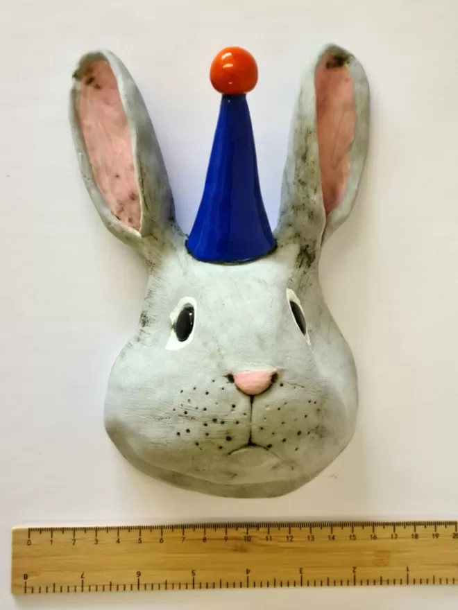 Bobby the rabbit trophy style head seen next to a ruler for scale.