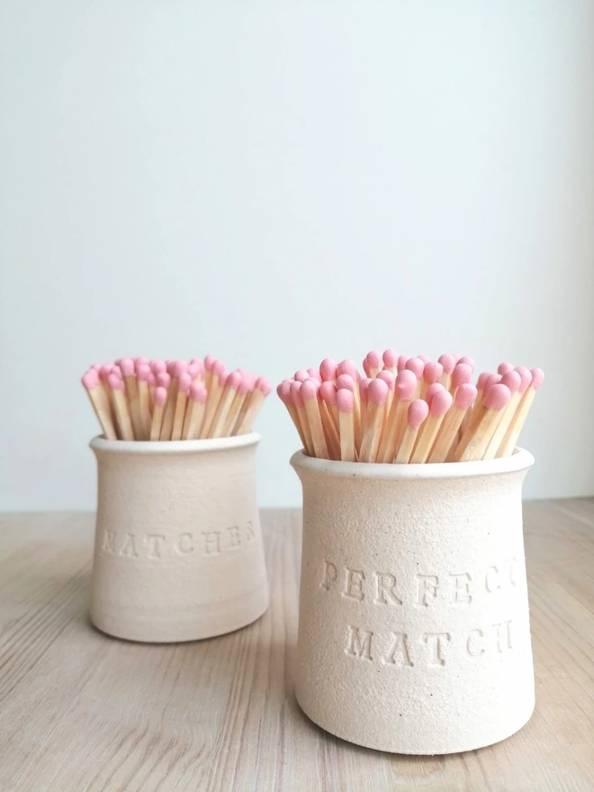 Two match pots one with perfect match stamped on and the other with matches stamped on. oeach coloured matches in both pots