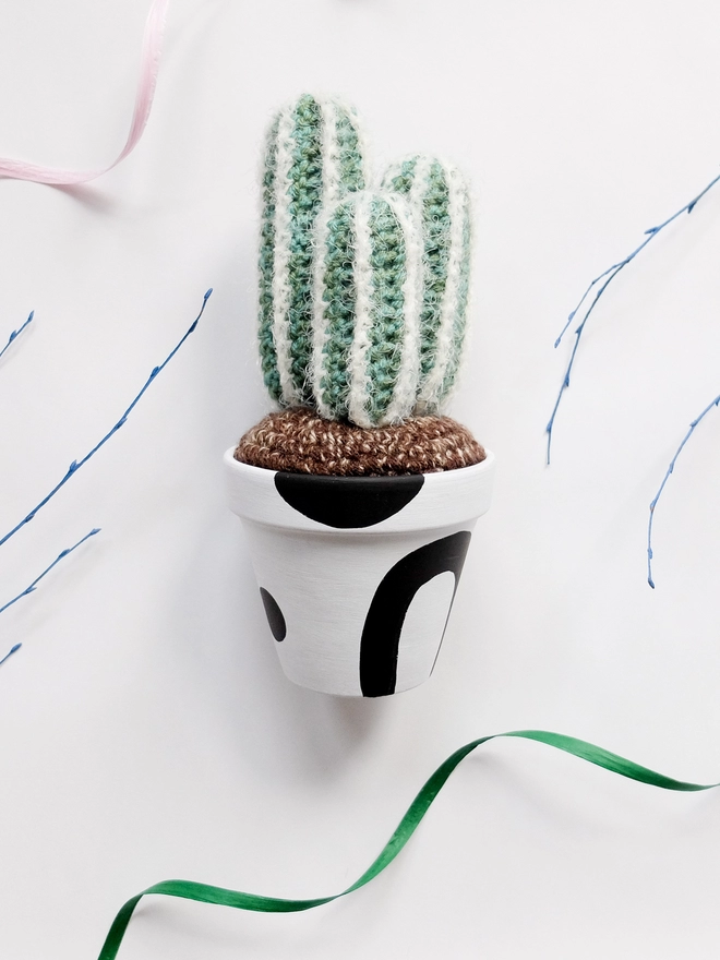 Crocheted fluffy cactus in a hand-painted terracotta pot