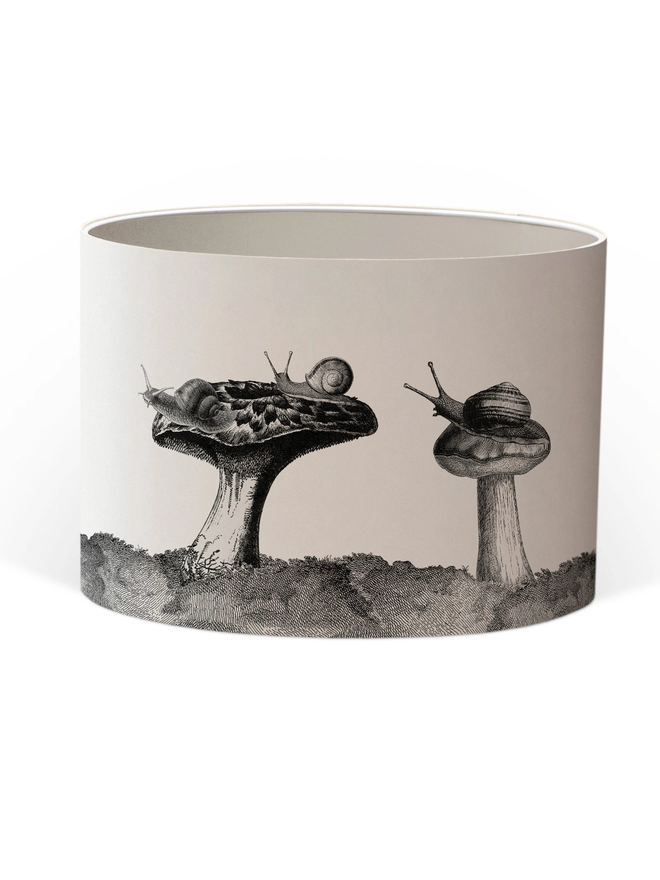Drum Lampshade featuring snails sitting on mushrooms and toadstools with a white inner on a white background