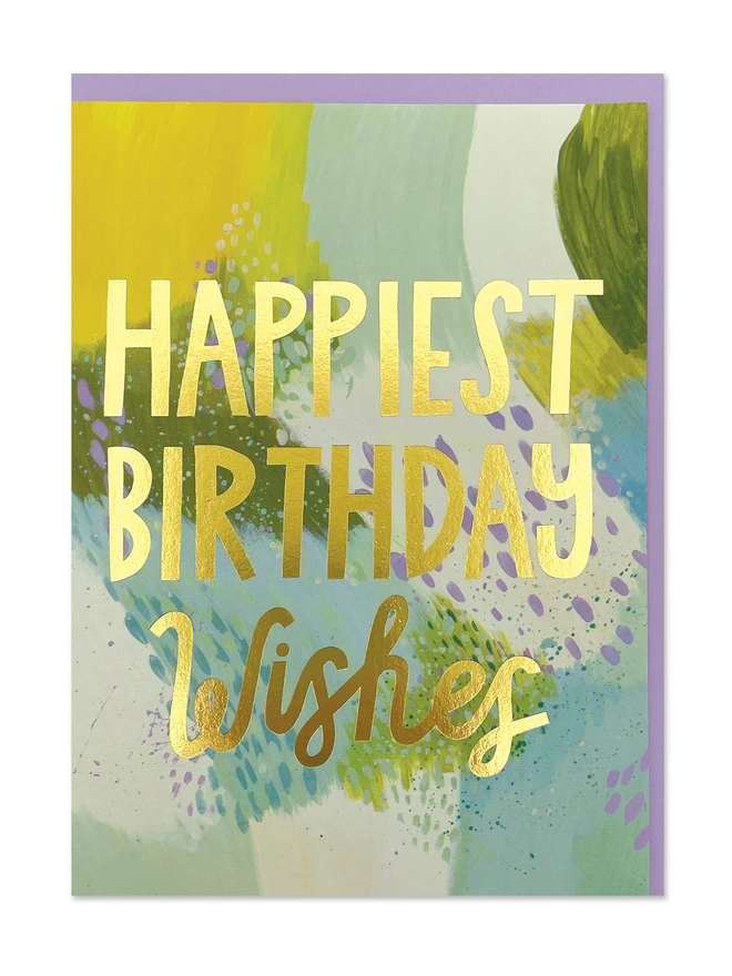 A painterly birthday card with abstract brush strokes and colourful paint splats in vibrant yellows, blues, cream and olive green. Finished with a gold foil ‘Happiest Birthday wishes’ message