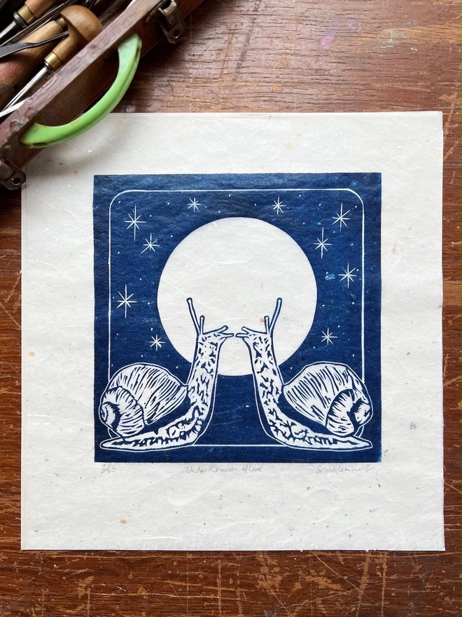 original linocut print of two snails and a full moon
