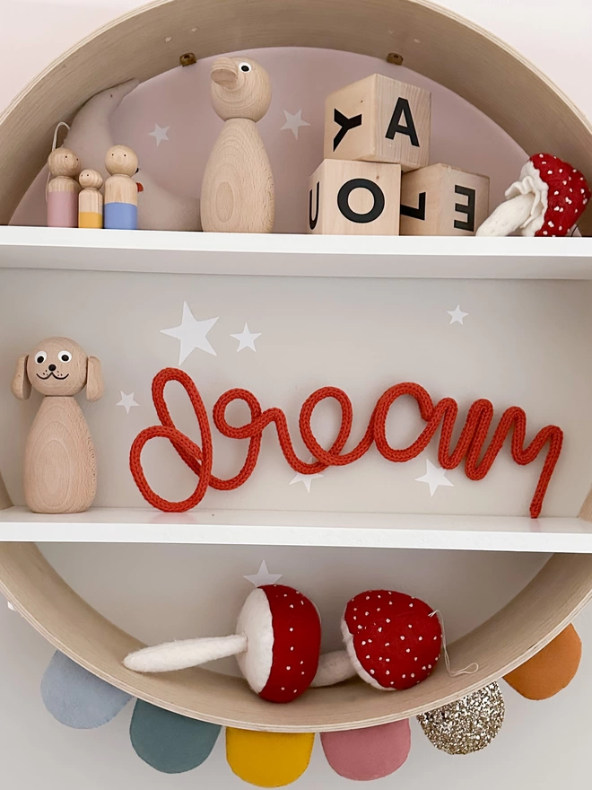 'dream' wall word decorating a shelf in a child's playroom full of kid's decor.