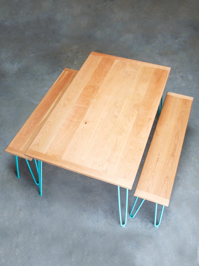 top down view of a hairpin leg dining table and benches with cherry wood tops and duck egg blue hairpin legs