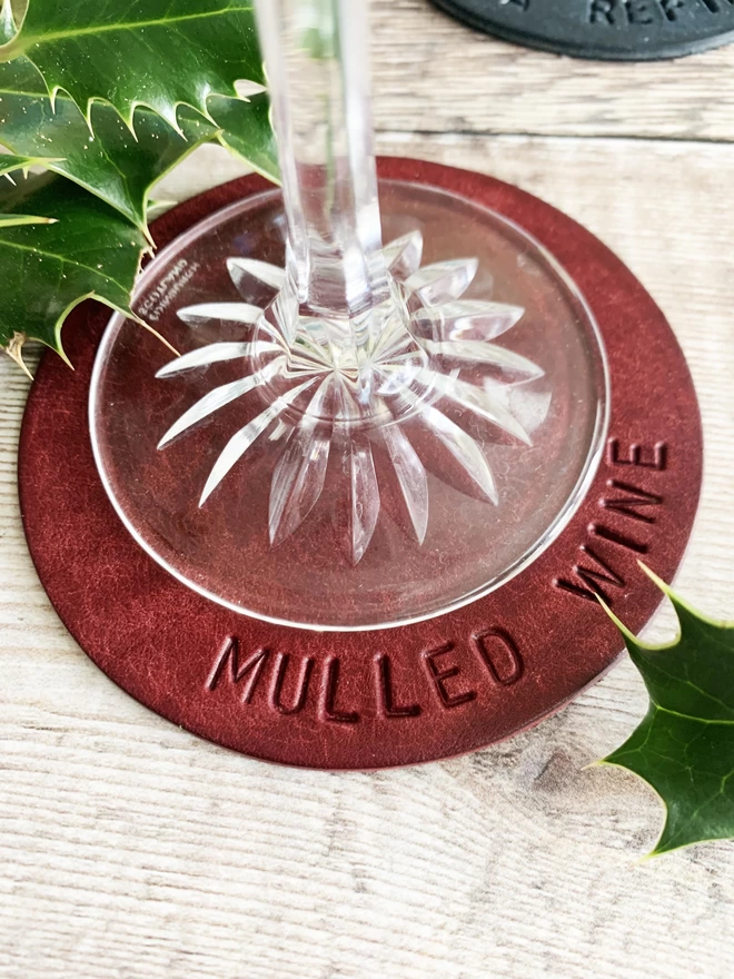 9cm Leather coaster in mulberry, stamped with Mulled Wine on the coaster.