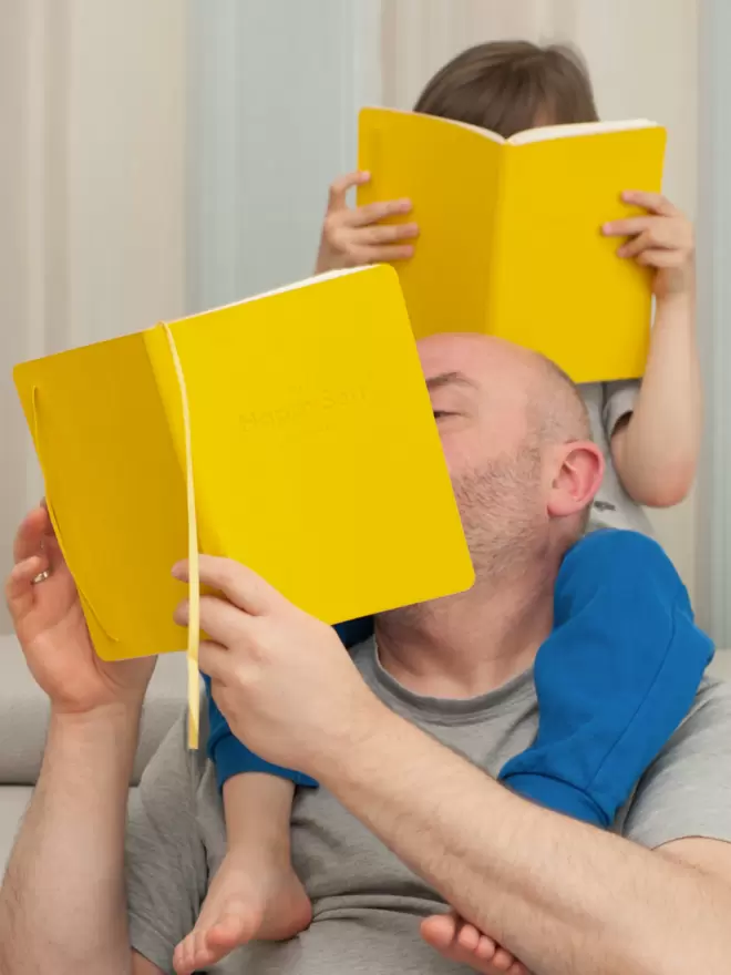 Father and son holding copies of their HappySelf Journals