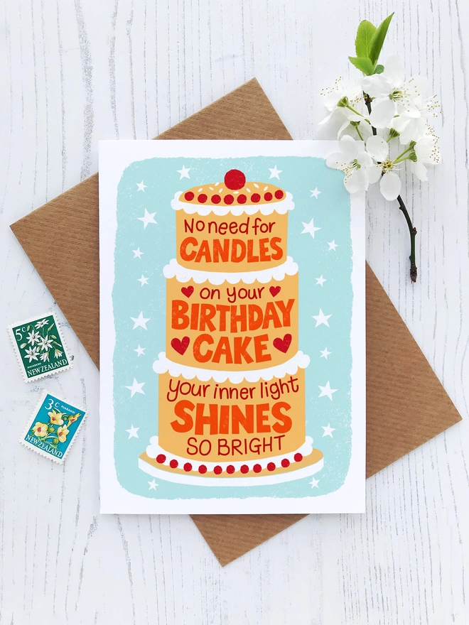 birthday candle cake with envelope stamps and white flower