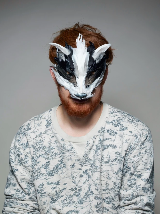 Man wearing luxury badger masquerade mask down over his face