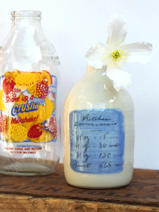 handmade ceramic bottle vase with flower and vintage glass milk bottle