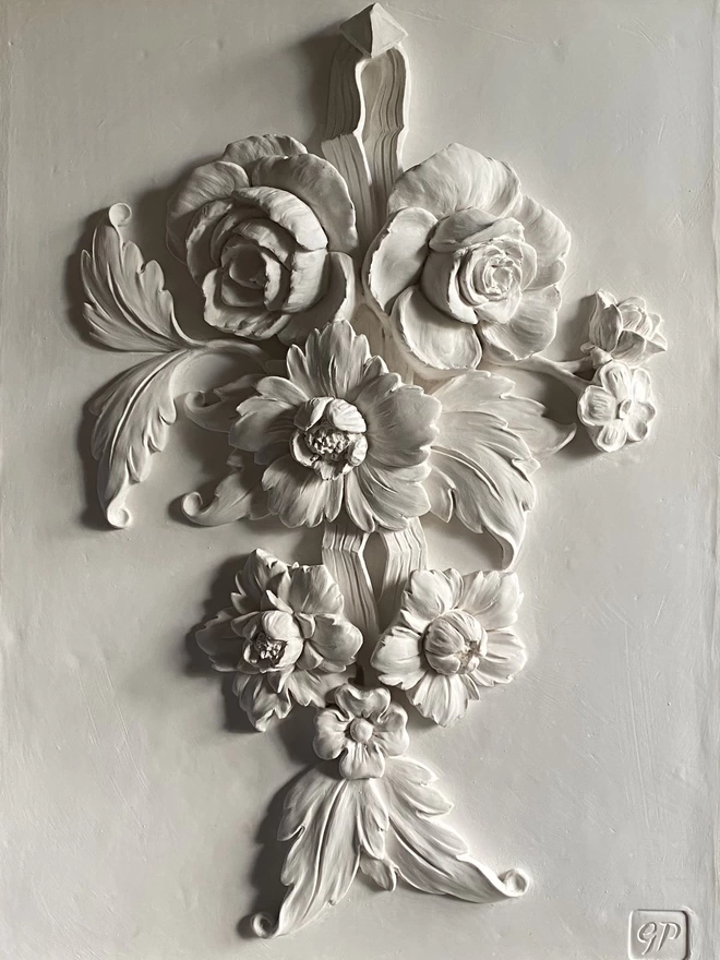 Detail of white plaster wall sculpture with flower design 