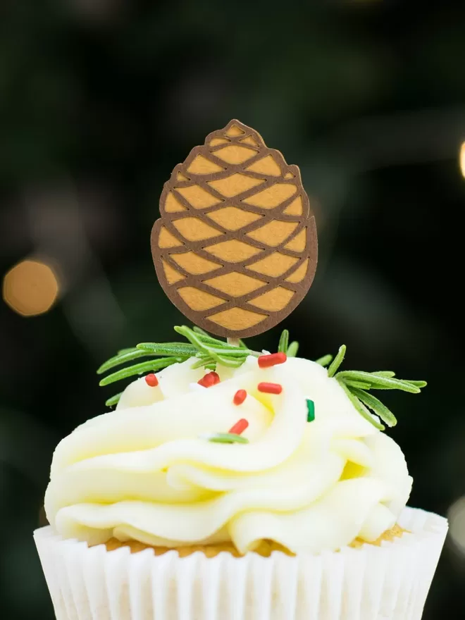 Paper pinecone cupcake decoration.  Pinecone is sienna brown with coffee brown detailing.