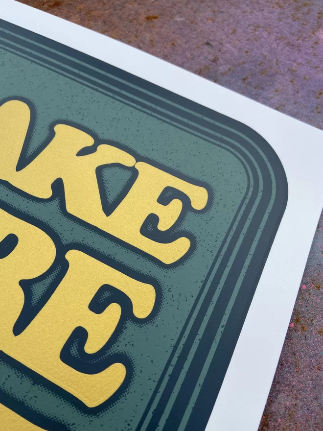 green leather looking screen print with gold letters that says “make more time for friends”