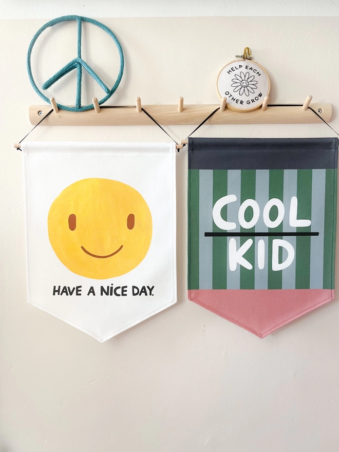Have a nice day smiley banner and cool kid stripes banner hanging from a wooden peg rail
