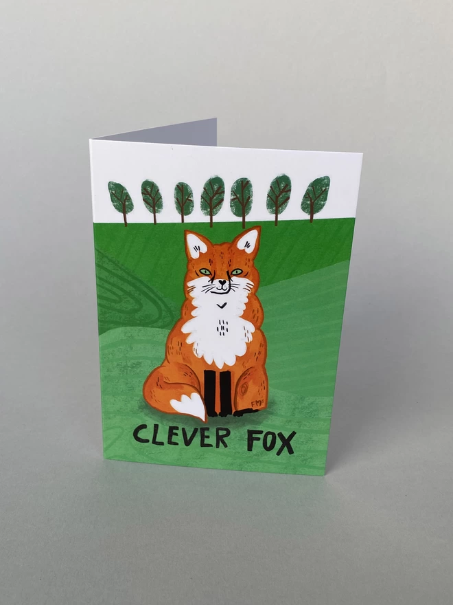 An illustration of an orange and white fox on an A6 Greeting card that reads - Clever Fox