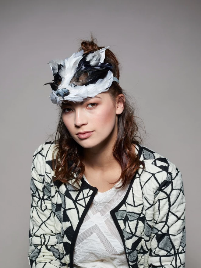 Woman wearing luxury badger masquerade mask atop her head as a headdress