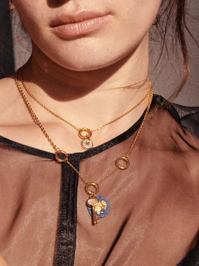 Woman wearing gold necklaces with pendants and charms