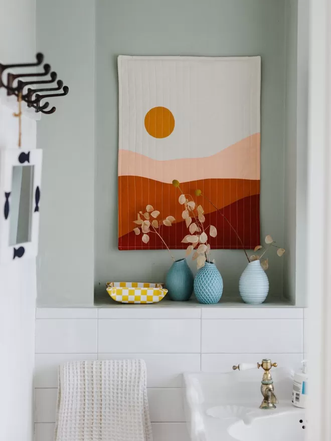 Earth Quilt Hanging On Blue Wall In Bathroom