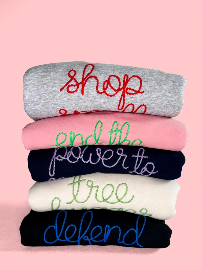A bundle of colourful embroidered sweatshirts