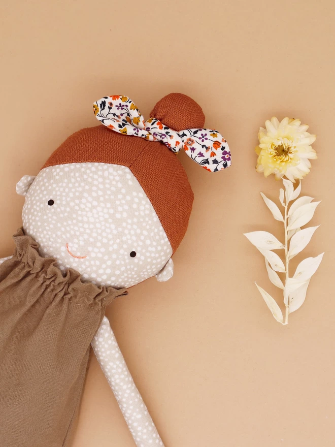 freckled face doll with orange hair and floral bow