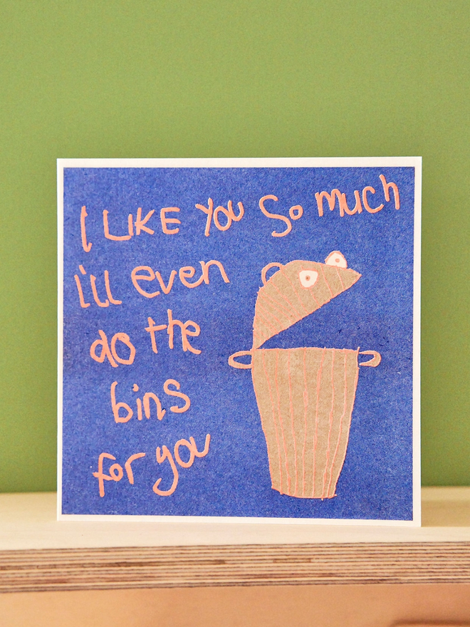 A bin on a deep blue background with fluro orange words saying I Like You So Much I'll even do the bins for you