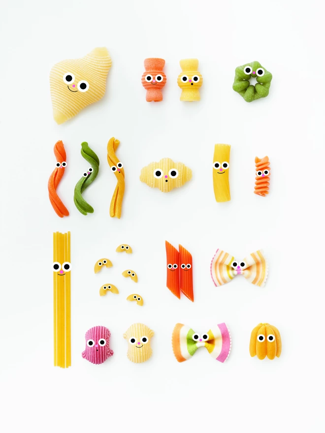 A colourful collection of pasta. each with little faces on a white background 