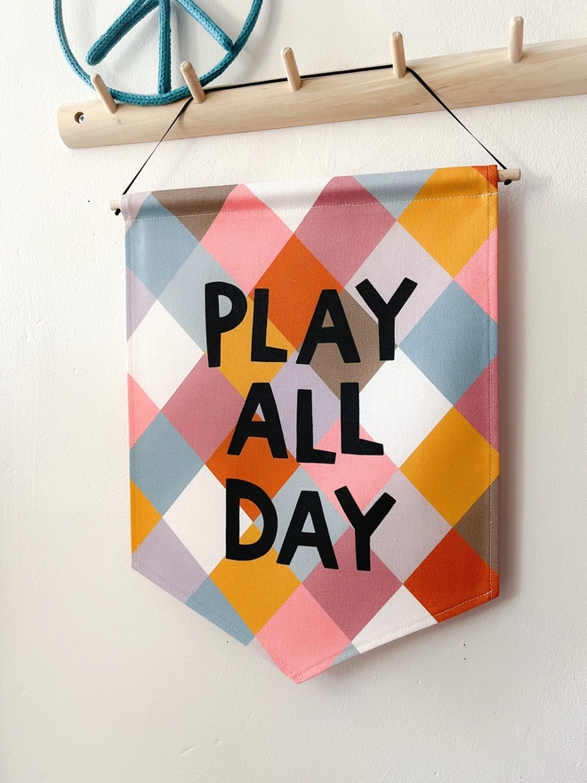 Printed sewn banner with muted colours with the words play all day