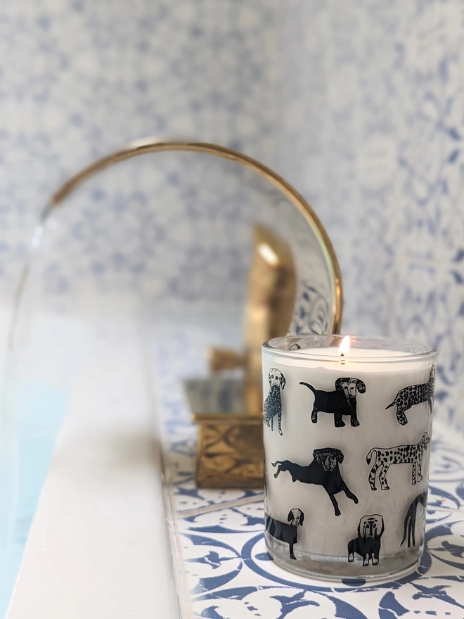 dogalicious rhubarb & ginger candle in a Reusable glass with black dog illustrations in bathroom setting