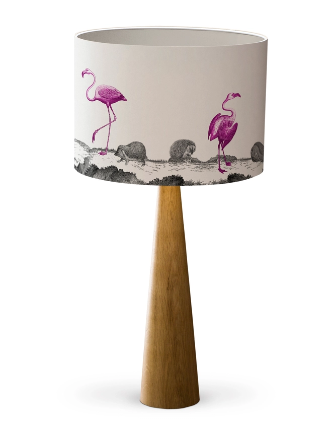 Drum Lampshade featuring pink flamingos and hedgehogs with a white inner on a wooden base on a white background