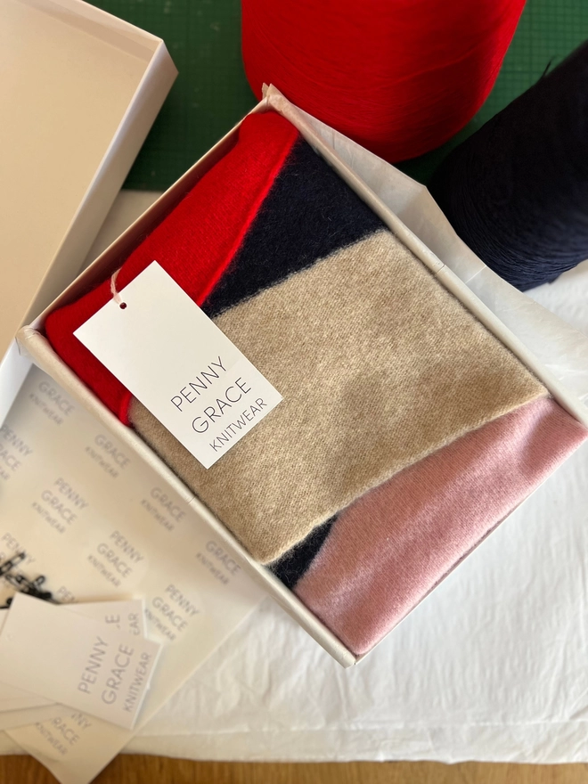 Red pink navy stripe scarf shown in gift box