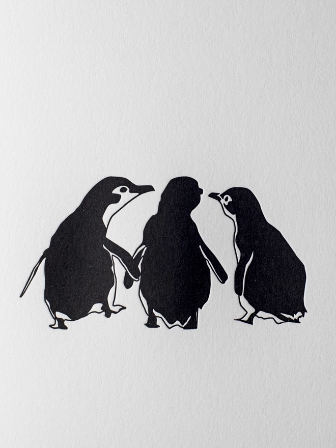 Close up of the Three cute little penguins that are letterpress printed on big card