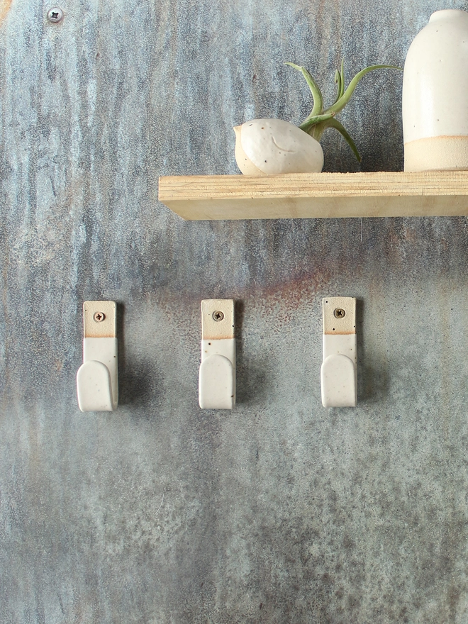 3 off-white wall hooks with matching decor