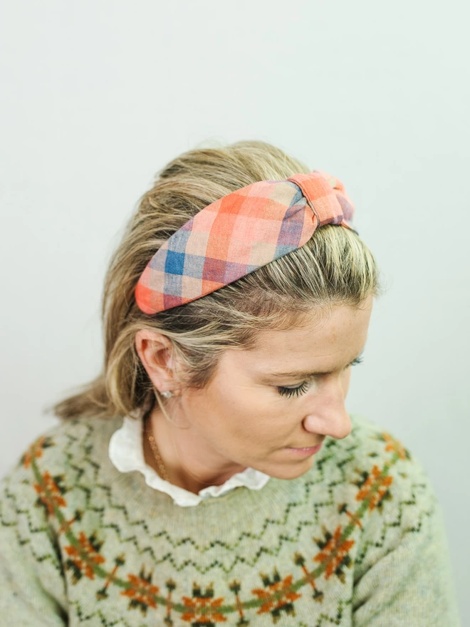 model wearing blue and red check hairband and jumper
